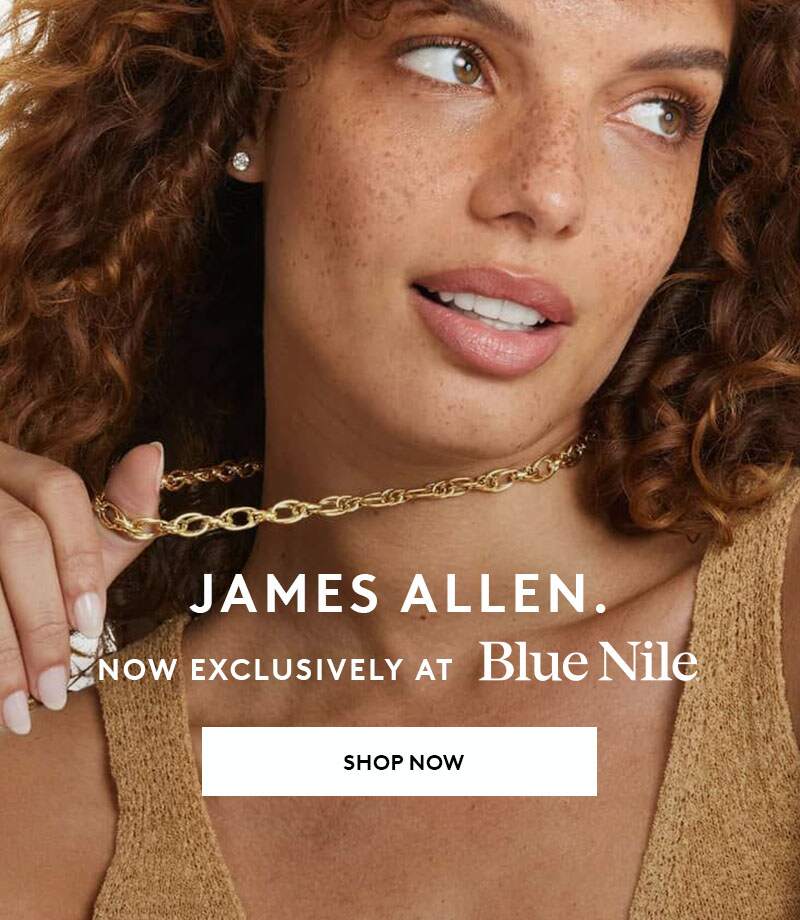 A woman with curly hair and freckles wearing a James Allen gold chain, exclusively at Blue Nile.