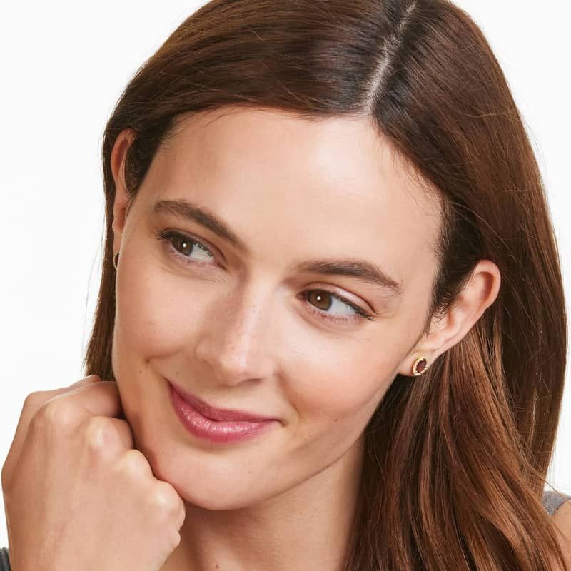 Oval Cut Garnet And Diamond Halo Stud Earrings In 14K Yellow Gold