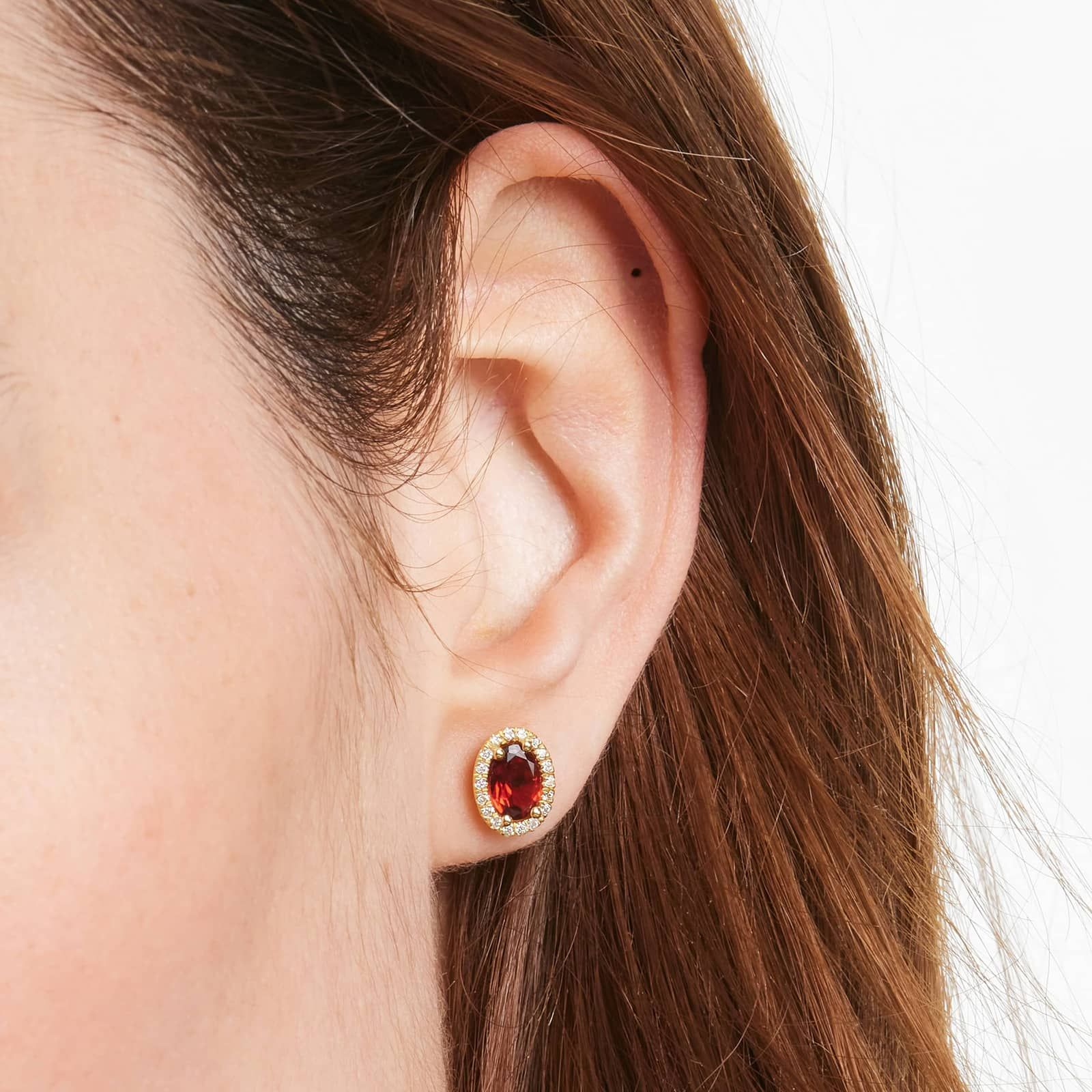 Oval Cut Garnet And Diamond Halo Stud Earrings In 14K Yellow Gold