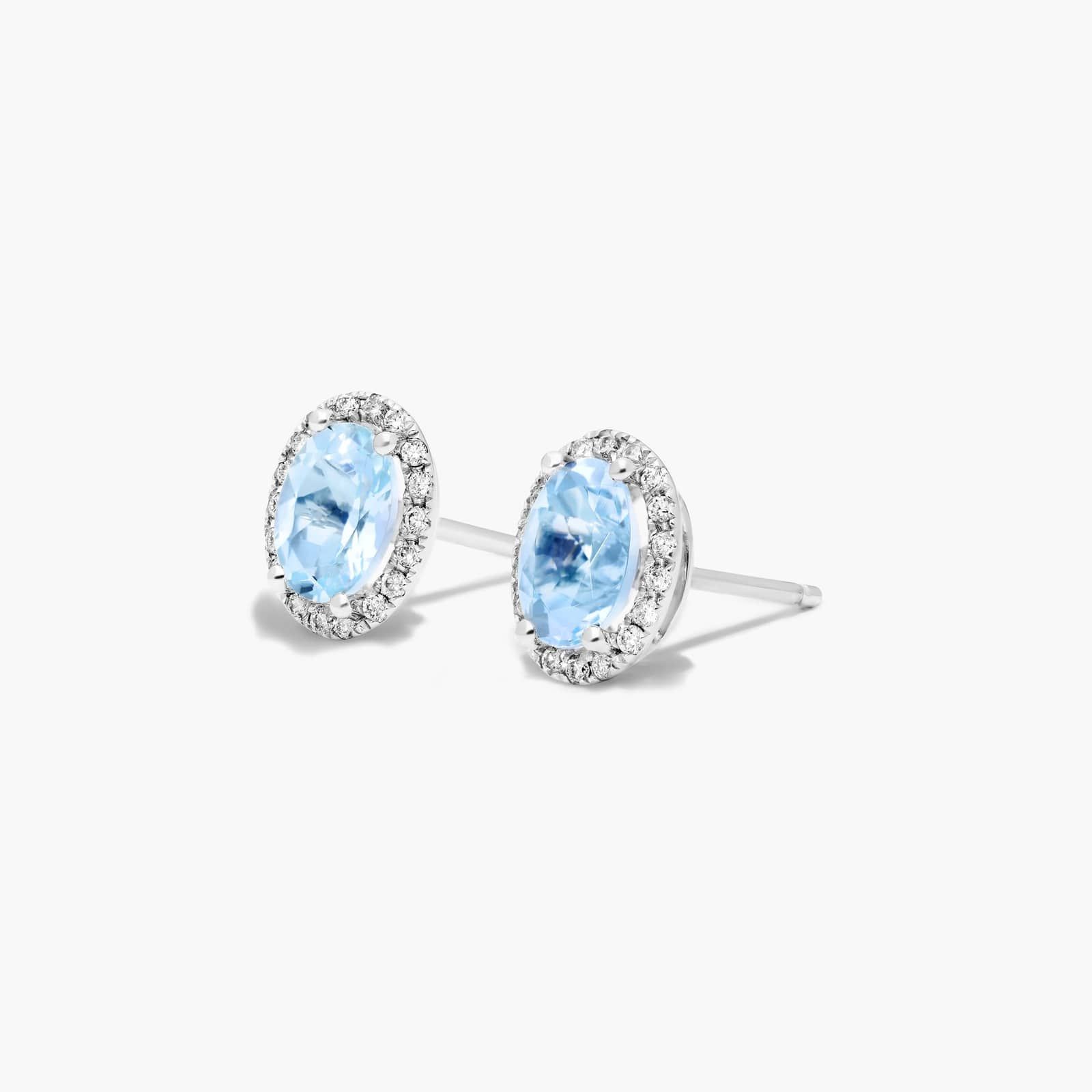 Oval Cut Aquamarine And Diamond Halo Stud Earrings In 14K White Gold