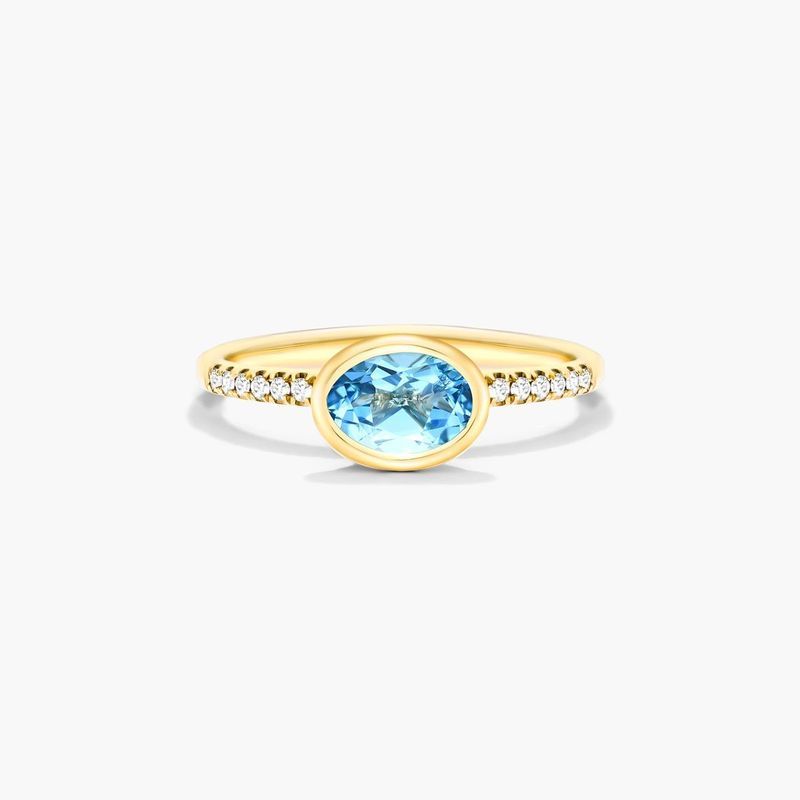 East-West Oval Blue Topaz And Diamond Ring In 18K Yellow Gold